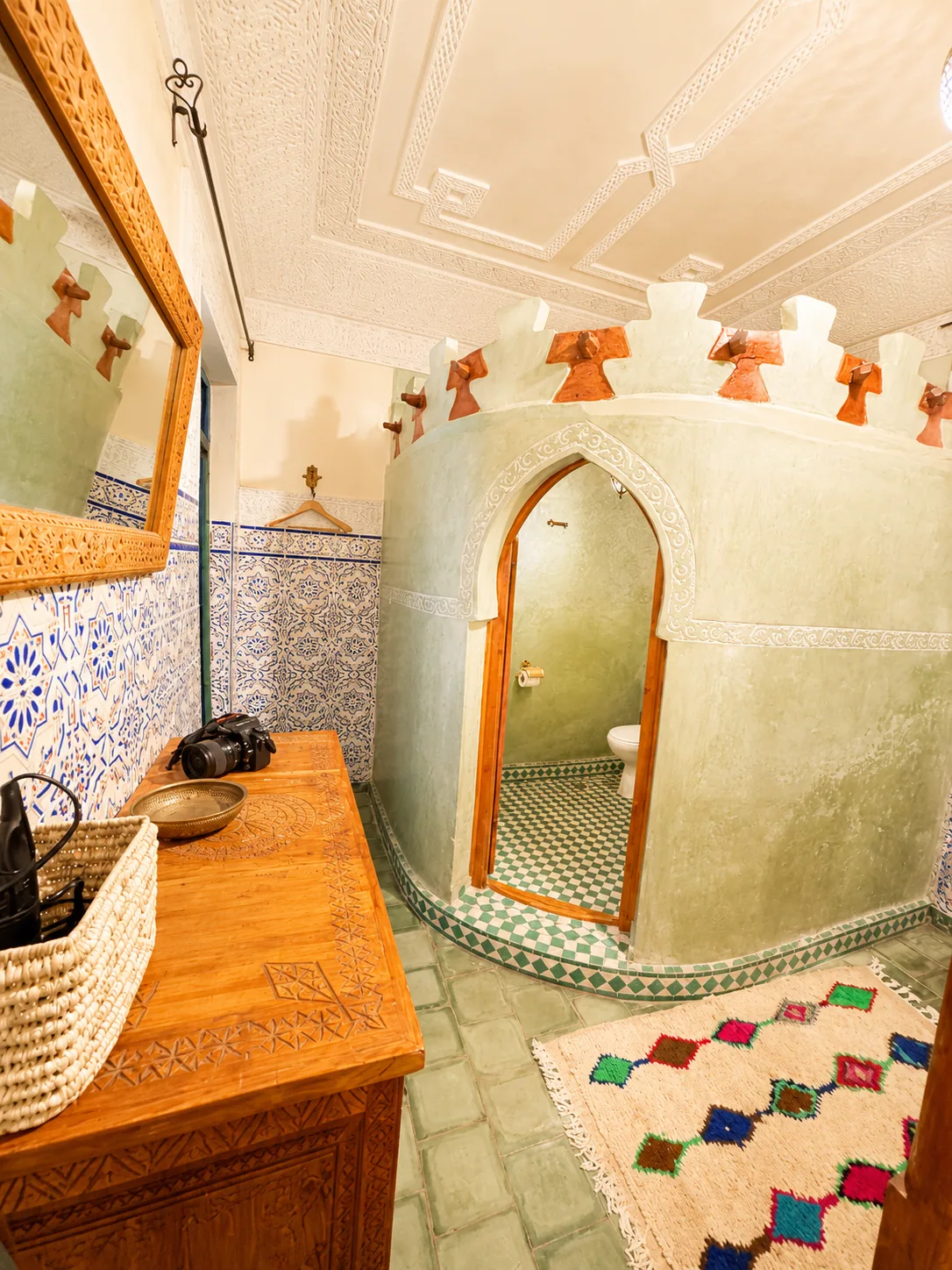 Dahab room: wide angle view showing the intricately carved stucco ceiling, oriental lamp, carved cabinet with mirror and the stained-glass door to the patio